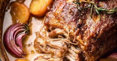 Apple cider braised pork shoulder dish garnished and ready to serve