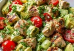 Delicious avocado chicken salad served in a bowl with fresh ingredients