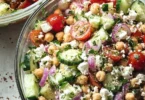 Colorful chickpea salad with fresh vegetables and herbs, served in a bowl