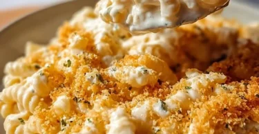 Bowl of creamy Boursin Mac and Cheese topped with herbs and cheese